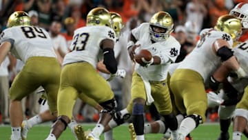 MIAMI GARDENS, FL - NOVEMBER 11: Brandon Wimbush #7 of the Notre Dame Fighting Irish hands off to Josh Adams #33 during a game against the Miami Hurricanes at Hard Rock Stadium on November 11, 2017 in Miami Gardens, Florida. (Photo by Mike Ehrmann/Getty Images)