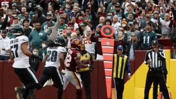 LANDOVER, MARYLAND - JANUARY 02: Jaret Patterson #32 of the Washington Football Team runs the ball for a touchdown in front of Anthony Harris #28 of the Philadelphia Eagles during the first quarter at FedExField on January 02, 2022 in Landover, Maryland. (Photo by Todd Olszewski/Getty Images)