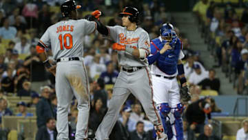 LOS ANGELES, CA - JULY 05: Manny Machado #13 is congratulated by Adam Jones #10 of the Baltimore Orioles after hitting a three-run homerun during the fifth inning of a baseball game while Yasmani Grandal #9 of the Los Angeles Dodgers looks on at Dodger Stadium on July 5, 2016 in Los Angeles, California. (Photo by Sean M. Haffey/Getty Images)