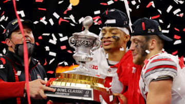 NEW ORLEANS, LOUISIANA - JANUARY 01: Head coach Ryan Day, Justin Fields #1 and Tuf Borland #32 of the Ohio State Buckeyes lift the trophy after defeating the Clemson Tigers 49-28 during the College Football Playoff semifinal game at the Allstate Sugar Bowl at Mercedes-Benz Superdome on January 01, 2021 in New Orleans, Louisiana. (Photo by Kevin C. Cox/Getty Images)
