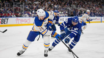 Mar 13, 2023; Toronto, Ontario, CAN; Buffalo Sabres forward Dylan Cozens (24) and Toronto Maple Leafs forward John Tavares (91) battle for the puck during the first period at Scotiabank Arena. Mandatory Credit: John E. Sokolowski-USA TODAY Sports