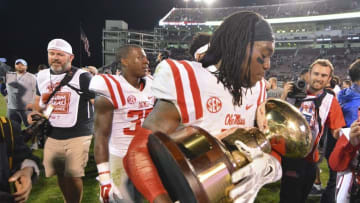 Nov 28, 2015; Starkville, MS, USA; Mississippi Rebels defensive back Trae Elston (7) celebrates with the Egg Bowl trophy after the game against the Mississippi State Bulldogs at Davis Wade Stadium. Mississippi won 38-27. Mandatory Credit: Matt Bush-USA TODAY Sports