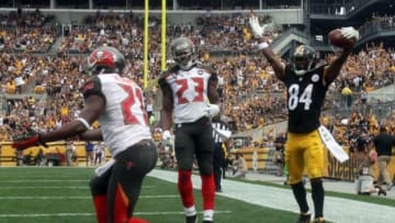 Sep 28, 2014; Pittsburgh, PA, USA; Pittsburgh Steelers wide receiver Antonio Brown (84) celebrates a touchdown pass around Tampa Bay Buccaneers cornerback Alterraun Verner (21) and safety Mark Barron (23) during the first quarter at Heinz Field. Mandatory Credit: Jason Bridge-USA TODAY Sports
