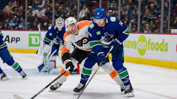 Feb 18, 2023; Vancouver, British Columbia, CAN; Philadelphia Flyers forward Noah Cates (49) battles with Vancouver Canucks defenseman Ethan Bear (74) in the second period at Rogers Arena. Mandatory Credit: Bob Frid-USA TODAY Sports