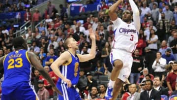 March 12, 2014; Los Angeles, CA, USA; Los Angeles Clippers guard Chris Paul (3) shoots against Golden State Warriors guard Steve Blake (25) and forward Draymond Green (23) during the second half at Staples Center. Mandatory Credit: Gary A. Vasquez-USA TODAY Sports