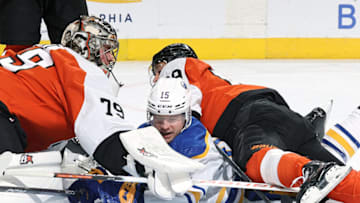 PHILADELPHIA, PENNSYLVANIA - NOVEMBER 01: Brandon Biro #15 of the Buffalo Sabres collides with Carter Hart #79 and Cam Atkinson #89 of the Philadelphia Flyers after scoring during the first period at the Wells Fargo Center on November 01, 2023 in Philadelphia, Pennsylvania. Biro scored his first-career NHL goal. (Photo by Tim Nwachukwu/Getty Images)