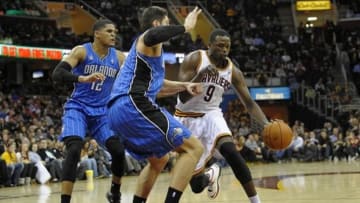 Feb 19, 2014; Cleveland, OH, USA; Cleveland Cavaliers small forward Luol Deng (9) drives against Orlando Magic small forward Tobias Harris (12) and center Nikola Vucevic (9) in the third quarter at Quicken Loans Arena. Mandatory Credit: David Richard-USA TODAY Sports