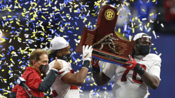 ATLANTA, GA - DECEMBER 19: Head coach Nick Saban, running back Najee Harris #22 and offensive lineman Alex Leatherwood #70 of the Alabama Crimson Tide hold up the SEC Championship trophy at the conclusion of the game against the Florida Gators during the SEC Championship game at Mercedes-Benz Stadium on December 19, 2020 in Atlanta, Georgia. (Photo by Todd Kirkland/Getty Images)