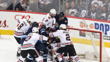 WINNIPEG, MB - APRIL 7: Goaltender Jeff Glass #30 of the Chicago Blackhawks guards the net as a mad scramble in the crease ensues during second period action against the Winnipeg Jets at the Bell MTS Place on April 7, 2018 in Winnipeg, Manitoba, Canada. (Photo by Jonathan Kozub/NHLI via Getty Images)