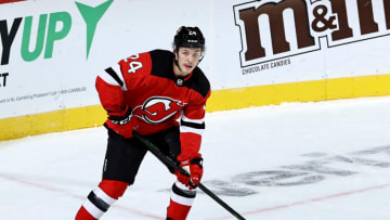NEWARK, NEW JERSEY - JANUARY 16: Ty Smith #24 of the New Jersey Devils takes the puck in the overtime period against the Boston Bruins at Prudential Center on January 16, 2021 in Newark, New Jersey. Due to Covid-19 restrictions, the game is played without fans. The New Jersey Devils defeated the Boston Bruins 2-1 in overtime. (Photo by Elsa/Getty Images)