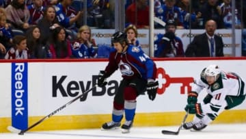 Oct 11, 2014; Denver, CO, USA; Colorado Avalanche defenseman Ryan Wilson (44) controls the puck ahead of Minnesota Wild left wing Zach Parise (11) in the second period at the Pepsi Center. Mandatory Credit: Isaiah J. Downing-USA TODAY Sports
