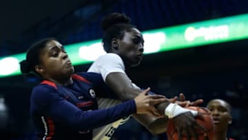 Dayton's Makira Cook and URI's Mayé Touré fighting for possession under the Rams hoop.