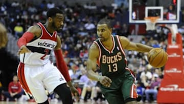 Apr 12, 2014; Washington, DC, USA; Milwaukee Bucks point guard Ramon Sessions (13) dribbles as Washington Wizards point guard John Wall (2) defends during the second half at Verizon Center. The Wizards won 104-91. Mandatory Credit: Brad Mills-USA TODAY Sports