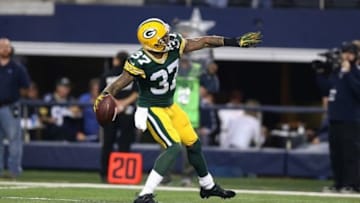 Dec 15, 2013; Arlington, TX, USA; Green Bay Packers cornerback Sam Shields (37) throws the ball into the stands after an interception in the fourth quarter against Dallas Cowboys receiver Miles Austin (19) at AT&T Stadium. The Packers beat the Cowboys 37-36. Mandatory Credit: Matthew Emmons-USA TODAY Sports