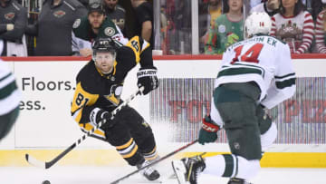 PITTSBURGH, PA - DECEMBER 20: Pittsburgh Penguins Right Wing Phil Kessel (81) skates with the puck around Minnesota Wild Center Joel Eriksson Ek (14) during the first period in the NHL game between the Pittsburgh Penguins and the Minnesota Wild on December 20, 2018, at PPG Paints Arena in Pittsburgh, PA. (Photo by Jeanine Leech/Icon Sportswire via Getty Images)