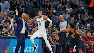 SAN ANTONIO, TX - DECEMBER 12: Dejounte Murray #5 of the San Antonio Spurs tries to save the ball from going out of bounds as Collin Sexton #2 of the Cleveland Cavaliers watches in the second half at AT&T Center on December 12, 2019 in San Antonio, Texas. NOTE TO USER: User expressly acknowledges and agrees that , by downloading and or using this photograph, User is consenting to the terms and conditions of the Getty Images License Agreement. (Photo by Ronald Cortes/Getty Images)