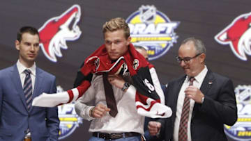 Jun 24, 2016; Buffalo, NY, USA; Jakob Chychrun puts on a team jersey after being selected as the number sixteen overall draft pick by the Arizona Coyotes in the first round of the 2016 NHL Draft at the First Niagra Center. Mandatory Credit: Timothy T. Ludwig-USA TODAY Sports