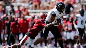 Cincinnati Bearcats tight end Leonard Taylor fights off a tackle against the Indiana Hoosiers. The Enquirer.