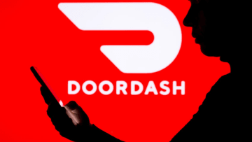 BRAZIL - 2022/04/01: In this photo illustration, a woman's silhouette holds a smartphone with the DoorDash logo in the background. (Photo Illustration by Rafael Henrique/SOPA Images/LightRocket via Getty Images)