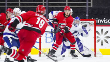Feb 22, 2021; Raleigh, North Carolina, USA; Carolina Hurricanes right wing Sebastian Aho (20) and Tampa Bay Lightning goaltender Andrei Vasilevskiy (88) watch the shot during the third period at PNC Arena. Mandatory Credit: James Guillory-USA TODAY Sports