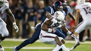 OXFORD, MS - OCTOBER 12: Linebacker Keith Lewis #24 of the Ole Miss Rebels tackles running back Ben Malena #1 of the Texas A&M Aggies on October 12, 2013 at Vaught-Hemingway Stadium in Oxford, Mississippi. At halftime Texas A&M leads Ole Miss 14-10. (Photo by Michael Chang/Getty Images)