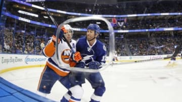 Mar 27, 2014; Tampa, FL, USA; Tampa Bay Lightning left wing Ryan Malone (12) checks New York Islanders defenseman Travis Hamonic (3) during the second period at Tampa Bay Times Forum. Mandatory Credit: Kim Klement-USA TODAY Sports