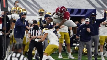Jan 1, 2021; Arlington, TX, USA; Alabama Crimson Tide running back Najee Harris (22) jumps over Notre Dame Fighting Irish cornerback Nick McCloud (4)during the Rose Bowl at AT&T Stadium. Mandatory Credit: Kirby Lee-USA TODAY Sports