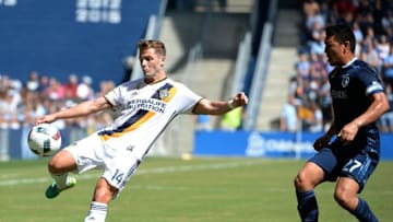 Sep 18, 2016; Kansas City, KS, USA; Los Angeles Galaxy forward Robbie Rogers (14) and Sporting Kansas City midfielder Roger Espinoza (27) go for the ball in the first half at Children
