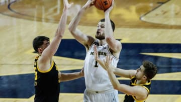 Michigan center Hunter Dickinson looks to shoot against Iowa center Luka Garza, left, and guard Jordan Bohannon during the second half at Crisler Center in Ann Arbor, Thursday, Feb. 25, 2021.