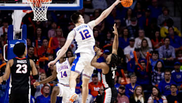 Jan 7, 2023; Gainesville, Florida, USA; Florida Gators forward Colin Castleton (12) blocks a shot from Georgia Bulldogs guard Kario Oquendo (3) during the second half at Exactech Arena at the Stephen C. O'Connell Center. Mandatory Credit: Matt Pendleton-USA TODAY Sports