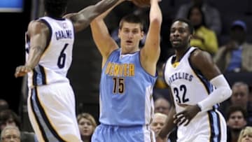 Jan 8, 2016; Memphis, TN, USA; Denver Nuggets center Nikola Jokic (15) handles the ball against Memphis Grizzlies guard Mario Chalmers (6) and forward Jeff Green (32) during the first half at FedExForum. Mandatory Credit: Justin Ford-USA TODAY Sports