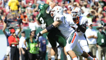 TAMPA, FL - SEPTEMBER 28: Quarterback Steven Bench #2 of the South Florida Bulls is hit by defensive lineman Anthony Chickillo #71of the Miami Hurricanes and linebacker Alex Figueroa #36 during the first half on September 28, 2013 at Raymond James Stadium in Tampa, Florida. (Photo by Brian Blanco/Getty Images)