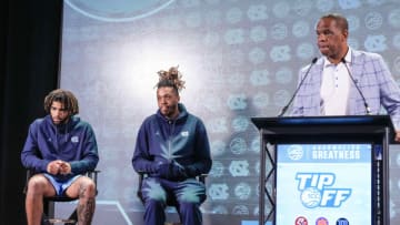 Oct 25, 2023; Charlotte, NC, USA; North Carolina players RJ Davis and Armando Bacot listen as coach Hubert Davis speaks to the media during the ACC Tipoff at Hilton Charlotte Uptown. Mandatory Credit: Jim Dedmon-USA TODAY Sports