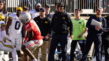 Nov 26, 2022; Columbus, Ohio, USA; Michigan Wolverines head coach Jim Harbaugh watches from the sideline beside off-field analyst Connor Stalions, right, during the NCAA football game against the Ohio State Buckeyes at Ohio Stadium.