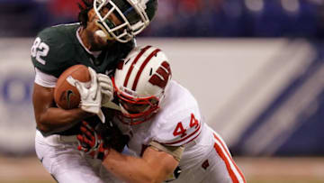 INDIANAPOLIS, IN - DECEMBER 03: Keshawn Martin #82 of the Michigan State Spartans loses his helmet as he is hit by Chris Borland #44 of the Wisconsin Badgers during the third quarter of the Big 10 Conference Championship Game at Lucas Oil Stadium on December 3, 2011 in Indianapolis, Indiana. (Photo by Gregory Shamus/Getty Images)