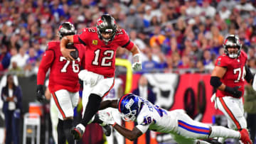 TAMPA, FLORIDA - NOVEMBER 22: Tom Brady #12 of the Tampa Bay Buccaneers carries the ball as Tae Crowder #48 of the New York Giants attempts a tackle in the second quarter in the game at Raymond James Stadium on November 22, 2021 in Tampa, Florida. (Photo by Julio Aguilar/Getty Images)