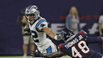 HOUSTON, TEXAS - SEPTEMBER 23: Christian McCaffrey #22 of the Carolina Panthers holds off Joe Thomas #48 of the Houston Texans at NRG Stadium on September 23, 2021 in Houston, Texas. (Photo by Bob Levey/Getty Images)