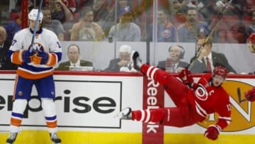 Oct 10, 2014; Raleigh, NC, USA; Carolina Hurricanes forward Eric Staal (12) is checked by the New York Islanders forward Matt Martin (17) during the 2nd period at PNC Arena. Mandatory Credit: James Guillory-USA TODAY Sports