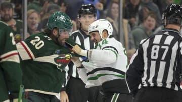 Oct 7, 2023; Saint Paul, Minnesota, USA; Minnesota Wild forward Pat Maroon (20) and Dallas Stars forward Jamie Benn (14) fight during the third period at Xcel Energy Center. Mandatory Credit: Nick Wosika-USA TODAY Sports