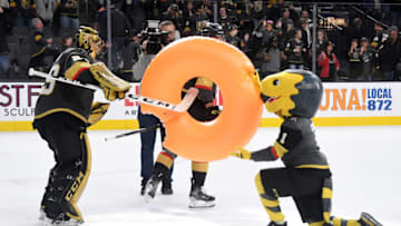 LAS VEGAS, NEVADA - FEBRUARY 26: Marc-Andre Fleury #29 of the Vegas Golden Knights takes an inflatable doughnut, signifying a shutout win, from the Golden Knights mascot Chance the Golden Gila Monster after the team's 3-0 victory over the Edmonton Oilers at T-Mobile Arena on February 26, 2020 in Las Vegas, Nevada. Fleury recorded his 61st career shutout tying Turk Broda for 17th all-time. (Photo by Ethan Miller/Getty Images)