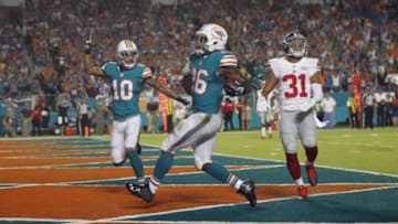 Dec 14, 2015; Miami Gardens, FL, USA; New York Giants defensive back Trevin Wade (31) reacts as Miami Dolphins running back Lamar Miller (26) scores and Dolphin wide receiver Kenny Stills (10) celebrates after a first quarter touchdown at Sun Life Stadium. Mandatory Credit: Andrew Innerarity-USA TODAY Sports