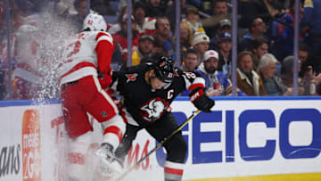 Dec 29, 2022; Buffalo, New York, USA; Buffalo Sabres right wing Kyle Okposo (21) checks Detroit Red Wings defenseman Jordan Oesterle (82) as he goes for a loose puck during the second period at KeyBank Center. Mandatory Credit: Timothy T. Ludwig-USA TODAY Sports