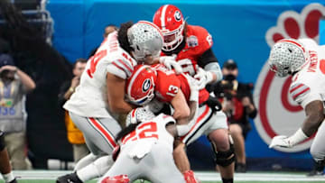 Dec 31, 2022; Atlanta, Georgia, USA; Ohio State Buckeyes linebacker Steele Chambers (22) and defensive end J.T. Tuimoloau (44) sack Georgia Bulldogs quarterback Stetson Bennett (13) during the first half of the Peach Bowl in the College Football Playoff semifinal at Mercedes-Benz Stadium. Mandatory Credit: Adam Cairns-The Columbus DispatchNcaa Football Peach Bowl Ohio State At Georgia