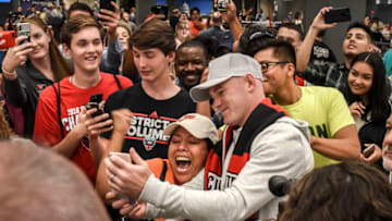 DULLES, VA - JUNE 28:Soccer star Wayne Rooney, center, takes selfies with fan Saida Cruz of Bristol, Va, as he arrives at Dulles Airport on June, 28, 2018 in Dulles, VA.(Photo by Bill O'Leary/The Washington Post via Getty Images)
