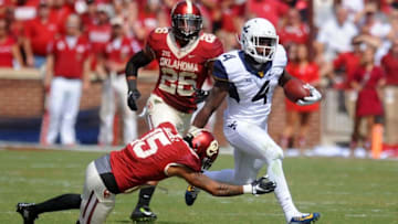 Oct 3, 2015; Norman, OK, USA; West Virginia Mountaineers running back Wendell Smallwood (4) carries the ball as Oklahoma Sooners cornerback Zack Sanchez (15) defends in the fourth quarter at Gaylord Family - Oklahoma Memorial Stadium. Mandatory Credit: Mark D. Smith-USA TODAY Sports