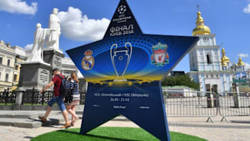 People walk past a star shaped billboard announcing the 2018 UEFA Champions League Final in the city centre of Kiev on May 17, 2018, ahead of the football match between Real Madrid and Liverpool FC next May 26 at the Olimpiyskiy Stadium. (Photo by Sergei SUPINSKY / AFP) (Photo credit should read SERGEI SUPINSKY/AFP/Getty Images)