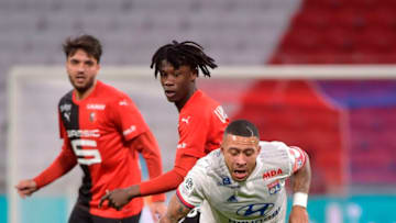 Lyon's Dutch forward Memphis Depay (R) falls on the pitch next to Rennes' French midfielder Eduardo Camavinga (C) and French midfielder Clement Grenier (L) during the French L1 football match between Lyon (OL) and Rennes (SR) on December 15, 2019, at the Groupama Stadium in Decines-Charpieu, near Lyon. (Photo by ROMAIN LAFABREGUE / AFP) (Photo by ROMAIN LAFABREGUE/AFP via Getty Images)
