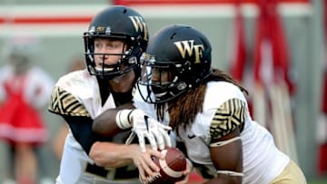 Oct 1, 2016; Raleigh, NC, USA; Wake Forest Deamon Deacons quarterback John Wolford (10) hands off to running back Rocky Reid (4) during the second half against the North Carolina State Wolfpack at Carter Finley Stadium. The Wolfpack won 33-16. Mandatory Credit: Rob Kinnan-USA TODAY Sports