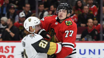 CHICAGO, ILLINOIS - OCTOBER 22: Kirby Dach #77 of the Chicago Blackhawks collides with Cody Eakin #21 of the Vegas Golden Knights during the third period at the United Center on October 22, 2019 in Chicago, Illinois. (Photo by Stacy Revere/Getty Images)