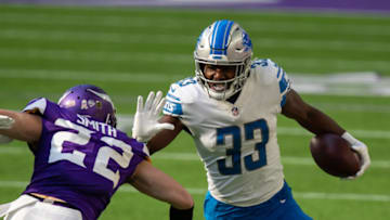 Nov 8, 2020; Minneapolis, Minnesota, USA; Detroit Lions running back Kerryon Johnson (33) runs with the ball in the second quarter against the Minnesota Vikings defensive back Harrison Smith (22) at U.S. Bank Stadium. Mandatory Credit: Brad Rempel-USA TODAY Sports